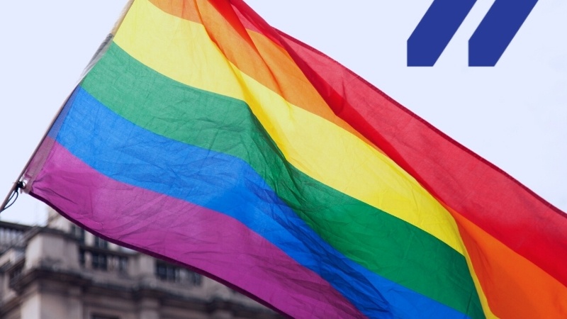 Image of a gay pride rainbow flag waving in the wind.