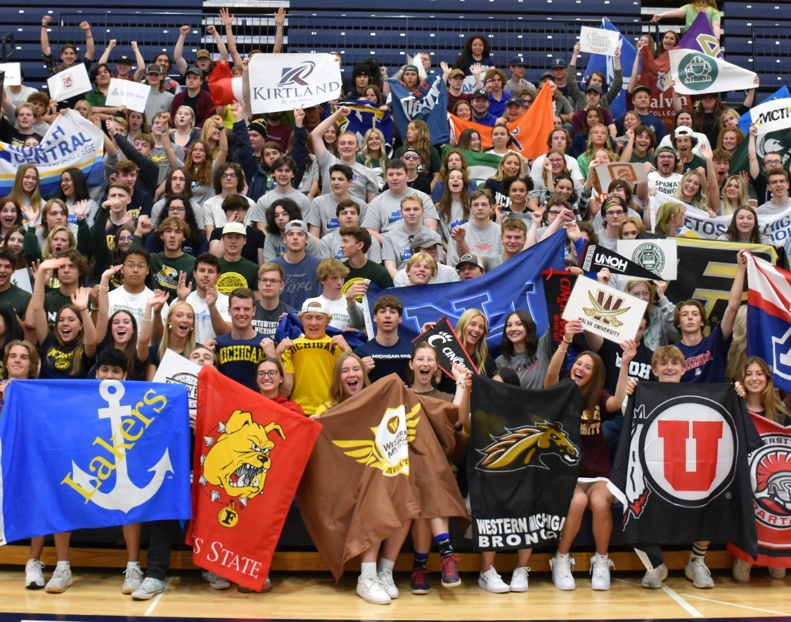Students holding flags and wearing shirts from Michigan colleges