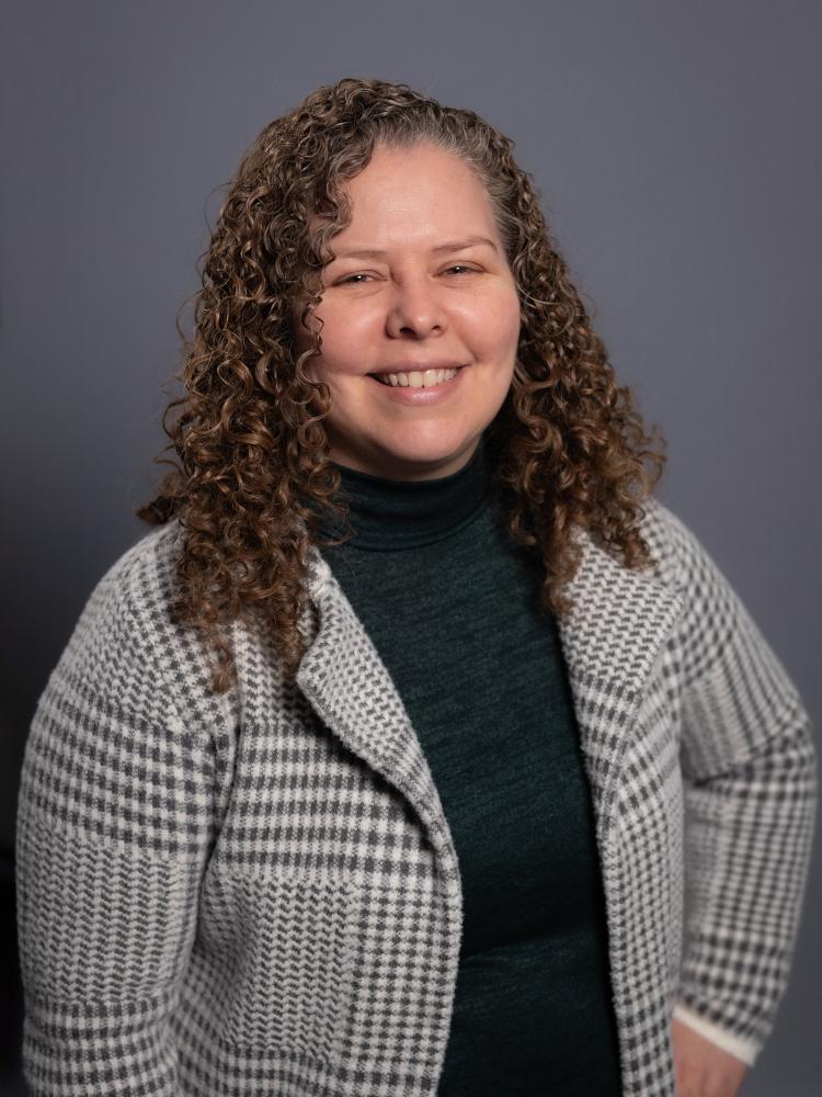 Trish Caldwell wearing a black shirt and light gray suit